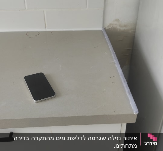 שולחן מטבח עם טלפון נייד וסימני רטיבות